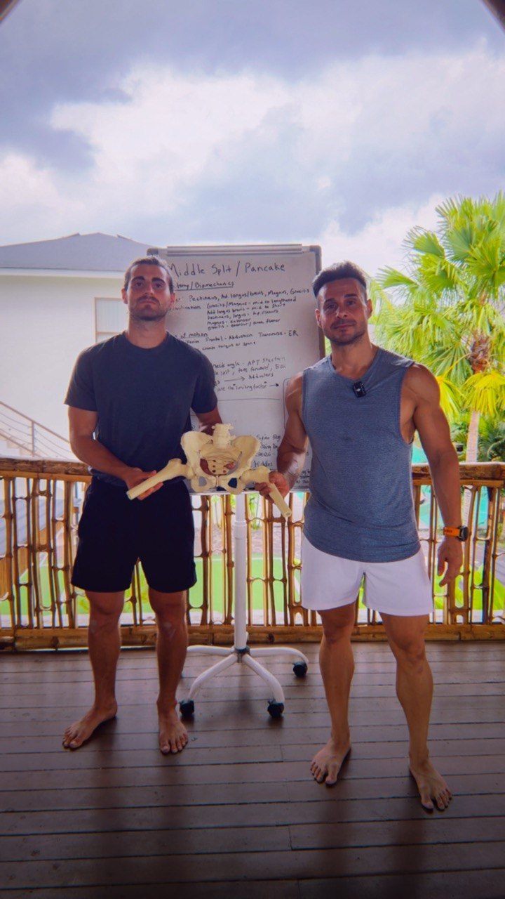 Coaches teaching hip anatomy with a pelvis model