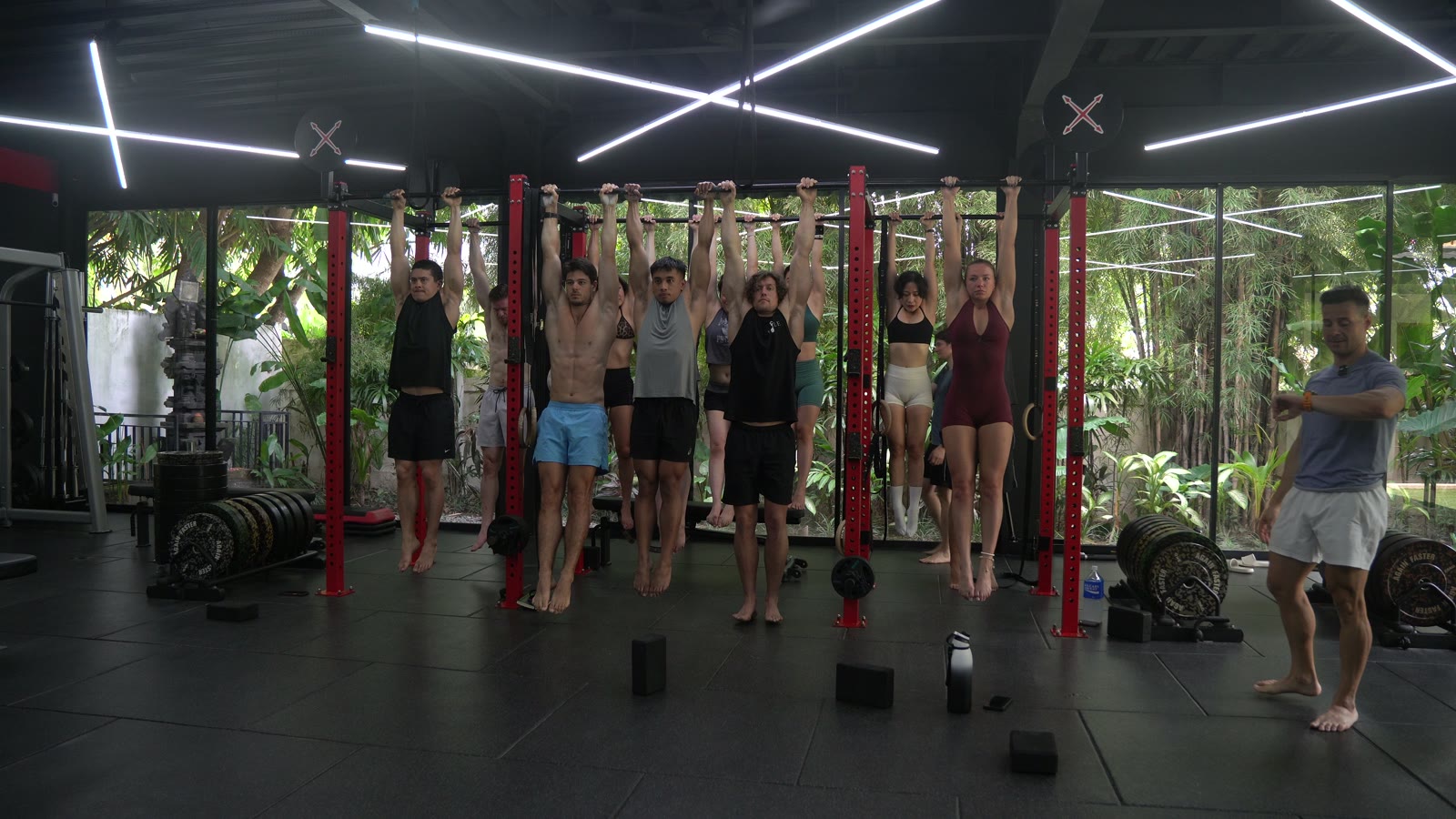 The group hanging from the pull-up bars during a session