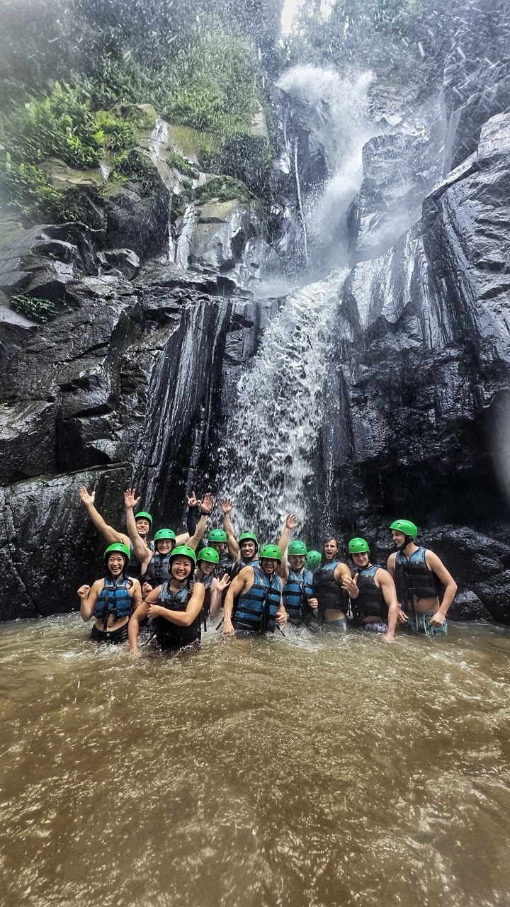 The group standing under a waterfall